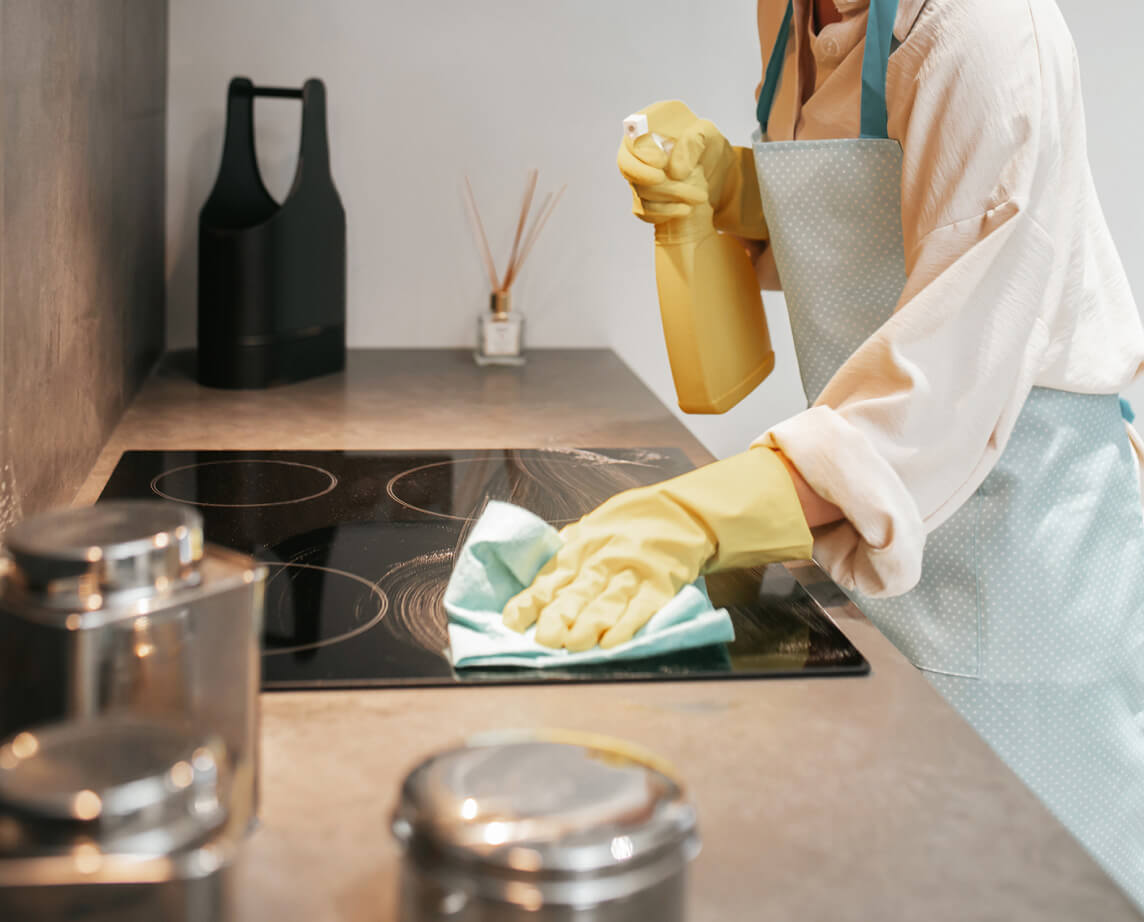 maid cleaning stove top